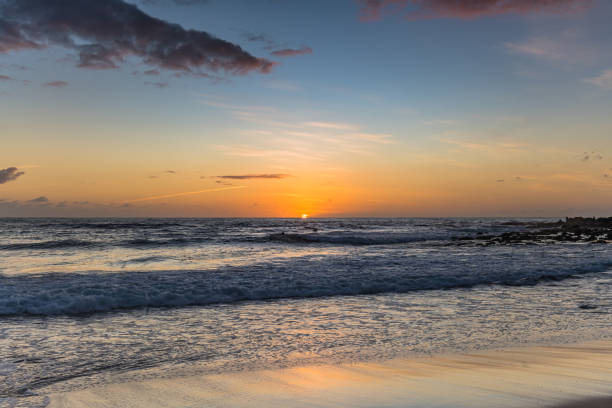 Early Mornings at the Beach as the sun rises on the horizon from MacMasters Beach on the Central Coast, NSW, Australia.