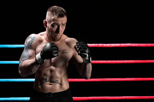 Photo of Mixed martial artist posing in boxing ring. Concept of mma, ufc, thai boxing, classic boxing.