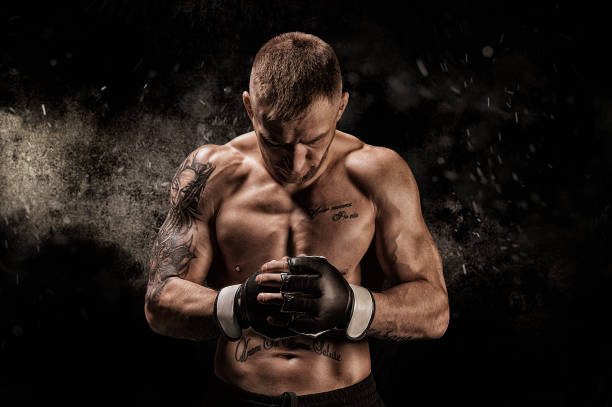 Mixed martial artist posing on a black background. Concept of mma, ufc, thai boxing, classic boxing. Mixed martial artist posing on a black background. Concept of mma, ufc, thai boxing, classic boxing. Mixed media combat sport photos stock pictures, royalty-free photos & images