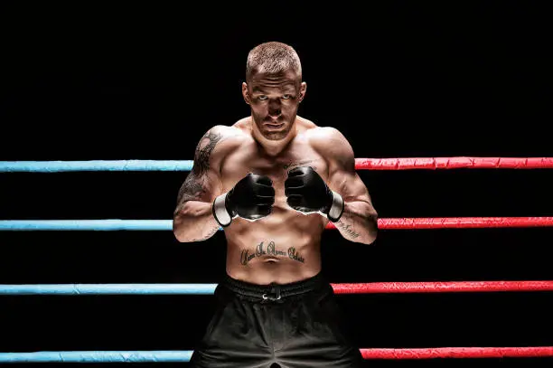 Photo of Mixed martial artist posing in boxing ring. Concept of mma, ufc, thai boxing, classic boxing.