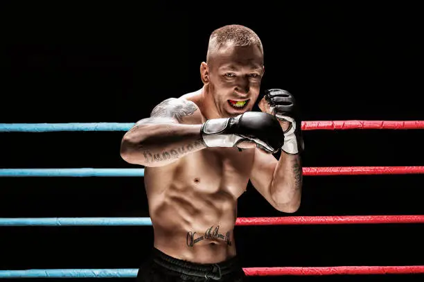 Photo of Mixed martial artist posing in boxing ring. Concept of mma, ufc, thai boxing, classic boxing.