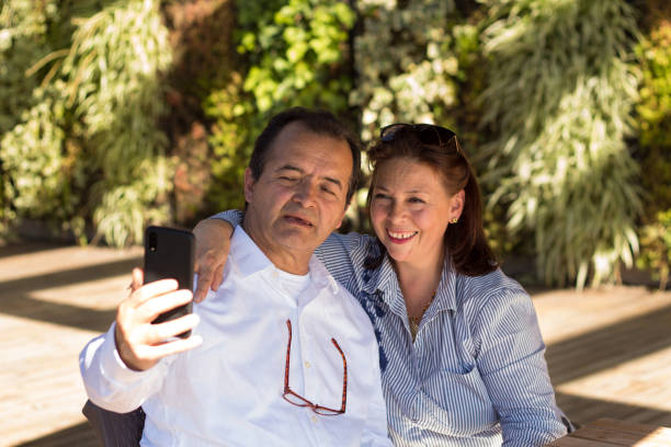 istock Happy couple using a smartphone while they are resting outside 1216653807
