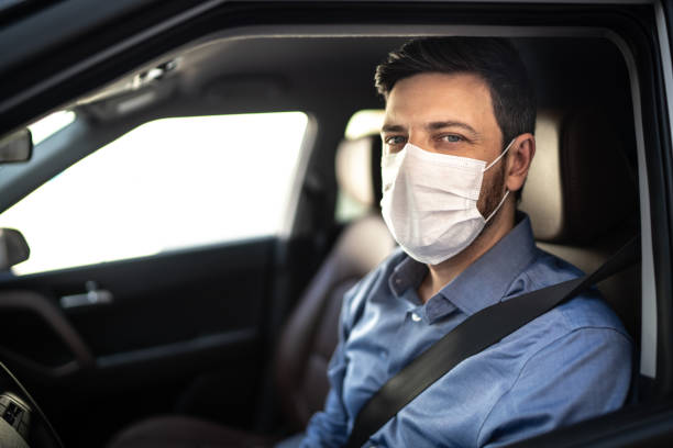 portrait of driver wearing protective medical mask - illness mask pollution car imagens e fotografias de stock