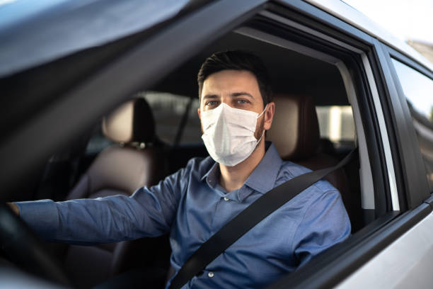 portrait of driver wearing protective medical mask - illness mask pollution car imagens e fotografias de stock
