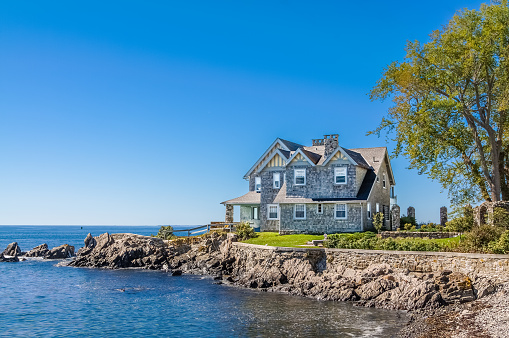 HDR image (photorealistic) of a Luxury House in New England, Kennebunkport, Maine. View from the Ocean avenue.