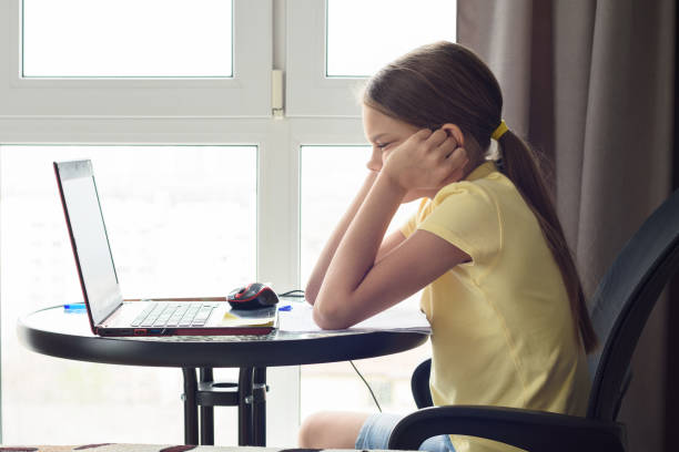 girl sitting in front of a laptop and thinking about a solution to a problem