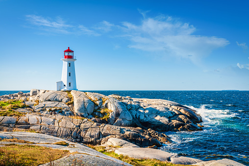 Peggy's Cove Lighthouse under blue summer sky. Peggy's Cove, Nova Scotia, Canada. Day and Night Series.