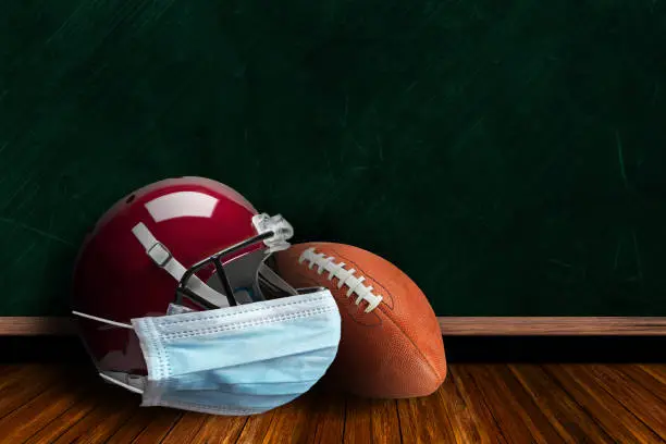 Photo of Football Helmet Wearing Mask With Chalkboard Background and Copy Space