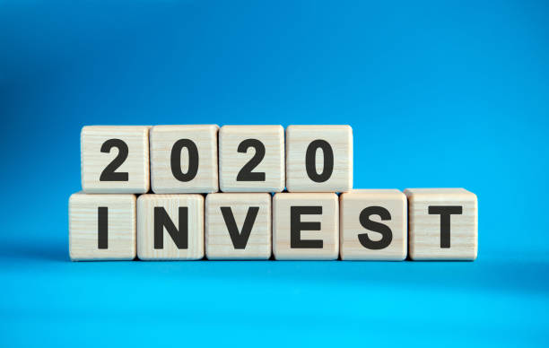 istock 2020 INVEST word cube on a blue background. 1216663786
