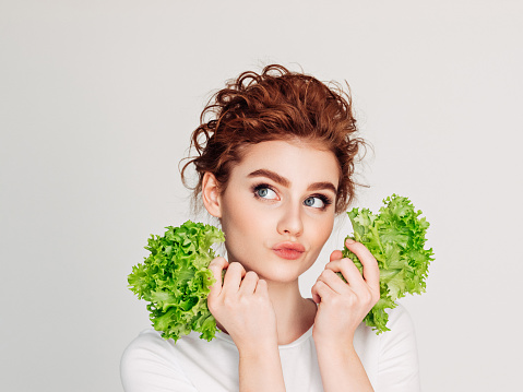 Young girl with leafs of salad