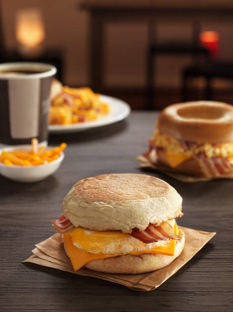 бутерброд с яйцом и беконом, сыр на завтрак состав на столе с картока фри и рогаликами - sandwich eggs bacon breakfast стоковые ф�ото и изображения