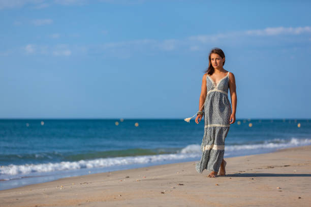 WOMAN WALKING ON THE SAND OF THE BEACH Young woman walking nude foots on the sand of the beach. Joy and freedom concept. mistral wind stock pictures, royalty-free photos & images