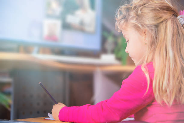 A little girl with her hair up and a headband, sits drawing. She pauses to engage you, understanding the importance of dialogue in building relationships and knowledge