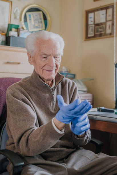 istock Old man wearing Protective Gloves against Covid-19 1216670296