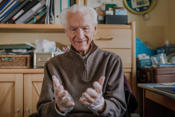 istock Elderly man puts on disposable protective gloves 1216671089