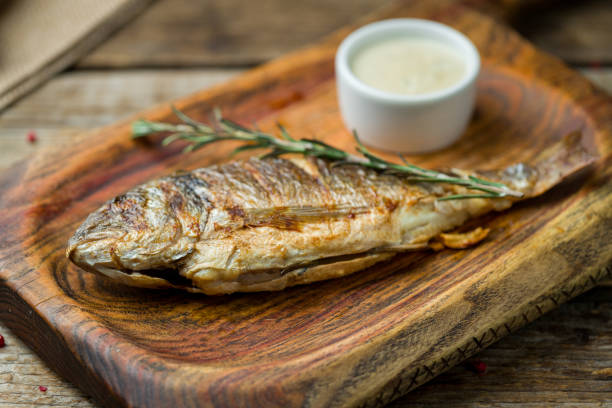 istock Dorado on grill on the board on wooden table 1216671391