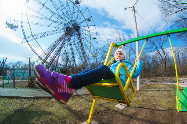 istock Laughing child on a swing in the spring park 1216672394