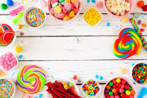 istock Sweet and colorful candy buffet frame, above view table scene over a white wood background 1216672876