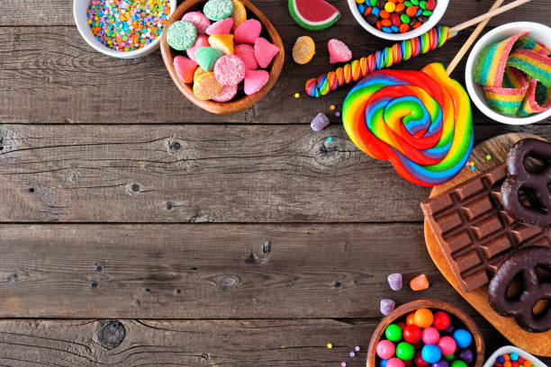 istock Colorful sweet candy buffet corner border, top view table scene over a rustic wood background 1216673767