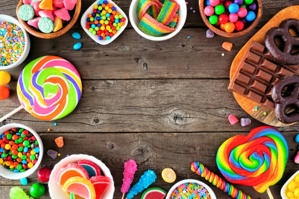 istock Sweet and colorful candy buffet frame, overhead view table scene with a rustic wood background 1216673771
