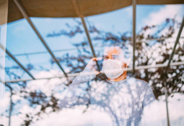istock Man in Quarantine Behind Glass 1216675155
