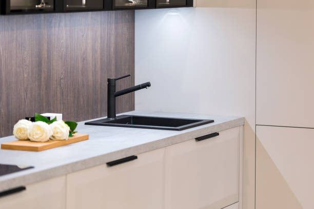 istock Contemporary luxury kitchen design in white color with black tap 1216677166