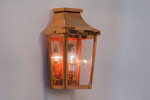 istock Modern streamlined mirror copper wall lamp. Metal classic lantern on gray background 1216677171