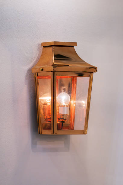 istock Modern streamlined mirror copper wall lamp. Metal classic lantern on gray background 1216677177