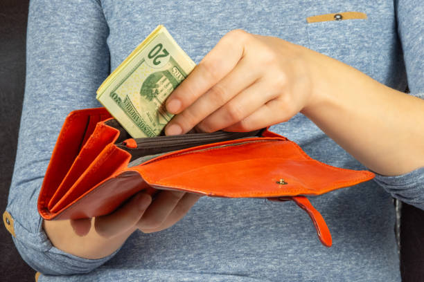 Earn quarantine. Woman puts dollars in a purse stock photo