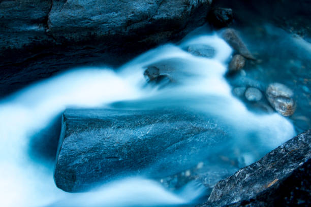 istock High mountain stream flows over green rocks in rugged environment 1216680656