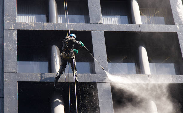 Construction worker power washes windows one of the office buildings in Downtown Vancouver stock photo