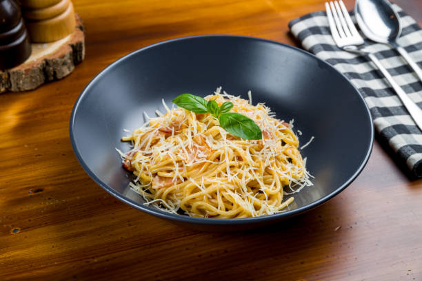 istock Spaghetti Carbonara with bacon on black plate on wooden table 1216682457