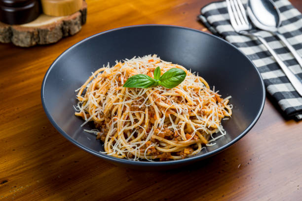 istock Pasta spaghetti Bolognese on black plate on wooden table 1216682503