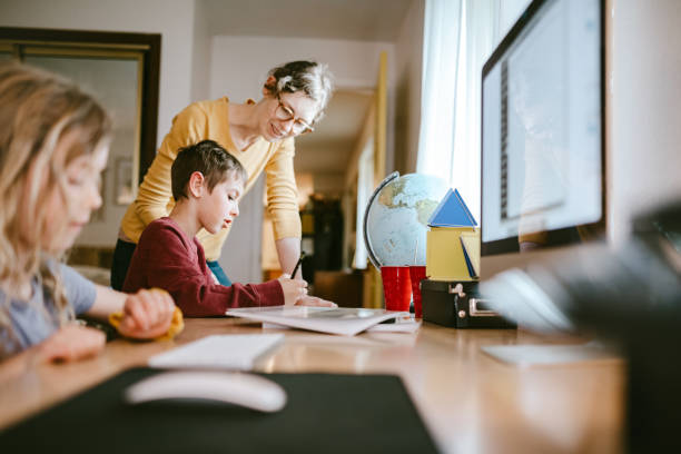 la famille fait des classes à la maison et en ligne - home schooling photos et images de collection