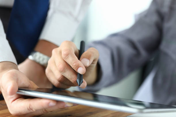 Man holds stylus and puts signature on tablet
