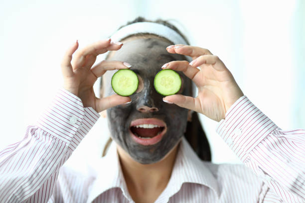 istock Girl with mask on her face shows slices cucumbers 1216687471