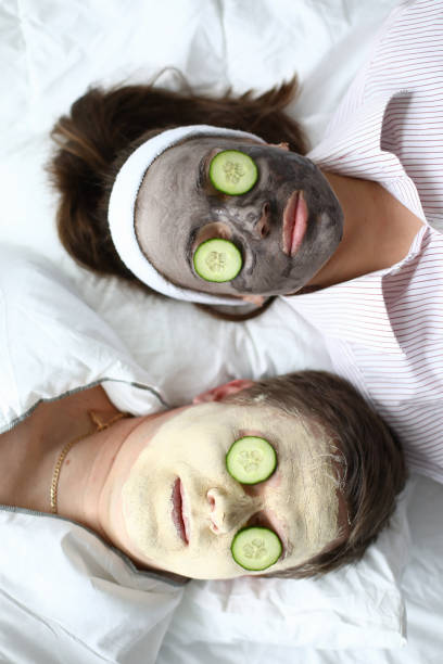 istock Man and woman put on face mask and cucumbers 1216687473