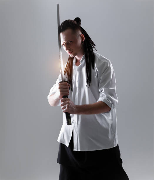 istock Young man holding a samurai sword. Glamour photo. 1216688626