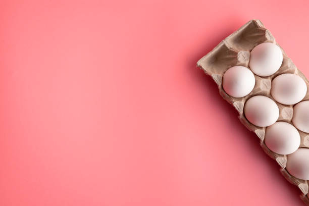 istock White chicken eggs in eco friendly paper tray on pink kitchen table flat lay 1216688627