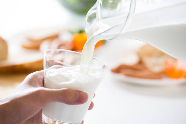 versando latte - milk morning adult women foto e immagini stock