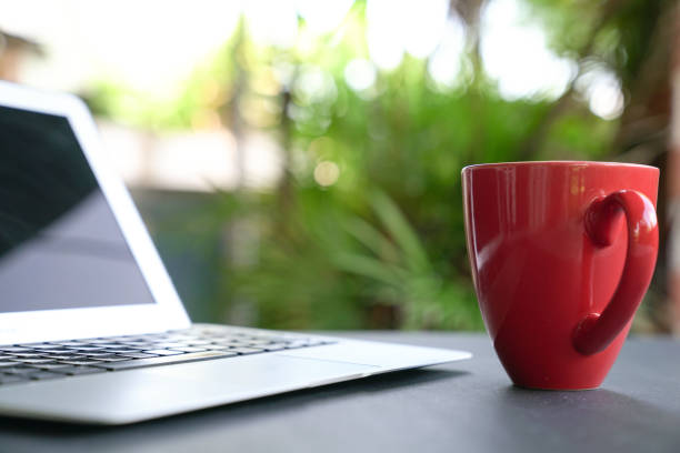 istock Computer laptop with coffee. Green nature background 1216696623