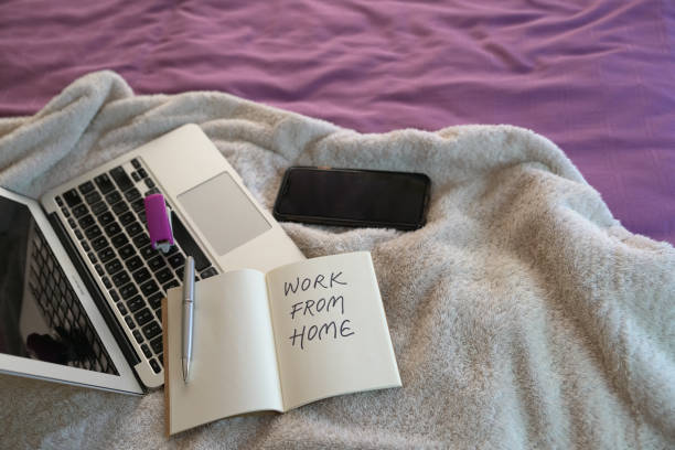istock Work from home. Computer laptop and cellphone on top of bed. 1216696631