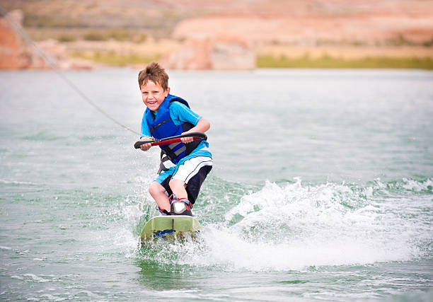 bambino imparare a wakeboard - wakeboarding foto e immagini stock