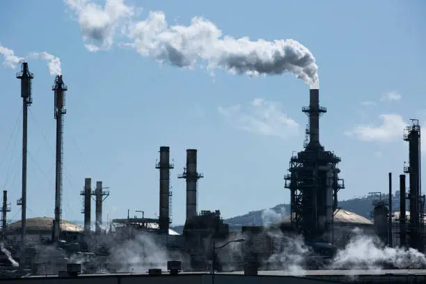 A refinery spews out greenhouse gases, one of the main causes of global warming, in the refining process of oil.