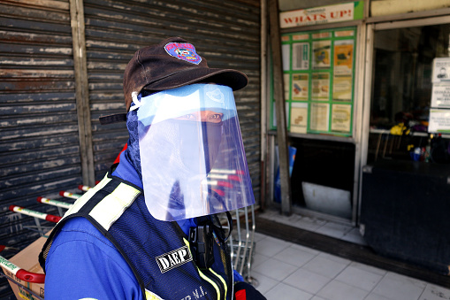 Antipolo City, Philippines - April 2, 2020: Police officer wear an improvised personal protective equipment while on duty during the lockdown or community quarantine due to Covid 19 virus outbreak.