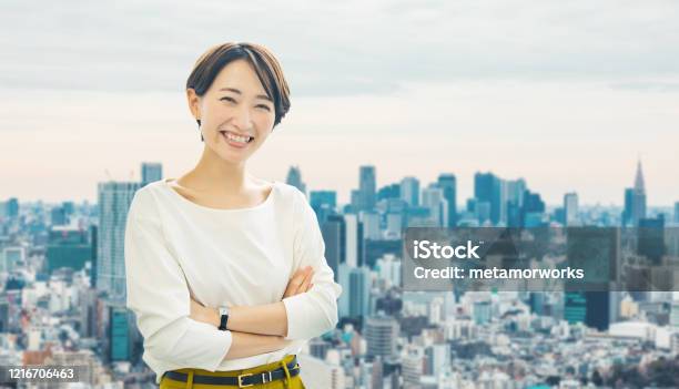 Middle Aged Asian Businesswoman In Front Of The City Stock Photo - Download Image Now