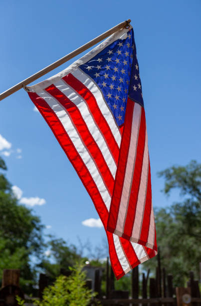 istock American Flag hanging against a blue sky 1216706554