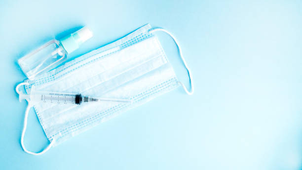 istock Antiseptic, medical mask and syringe on a blue background. 1216707365