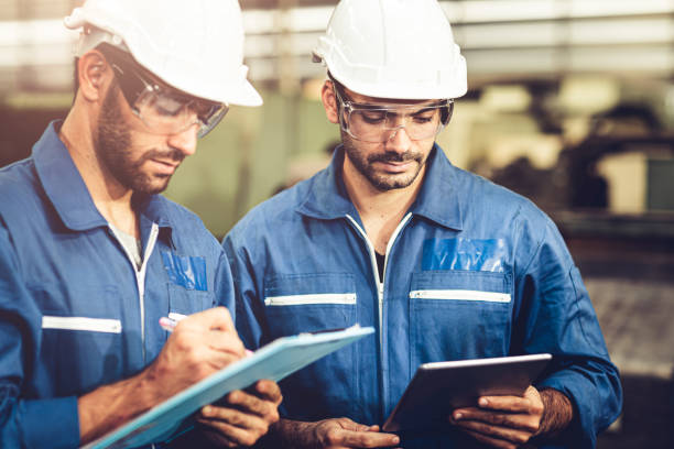 istock Engineer audit worker working team together with safety uniform and white helmet to work in industry factory handle tablet and checklist. 1216710504