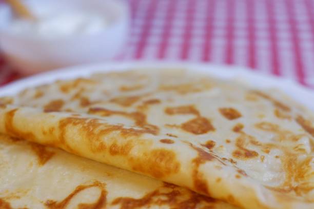 istock Delicious fried pancakes stack and sour cream in a cup on a plate 1216713252